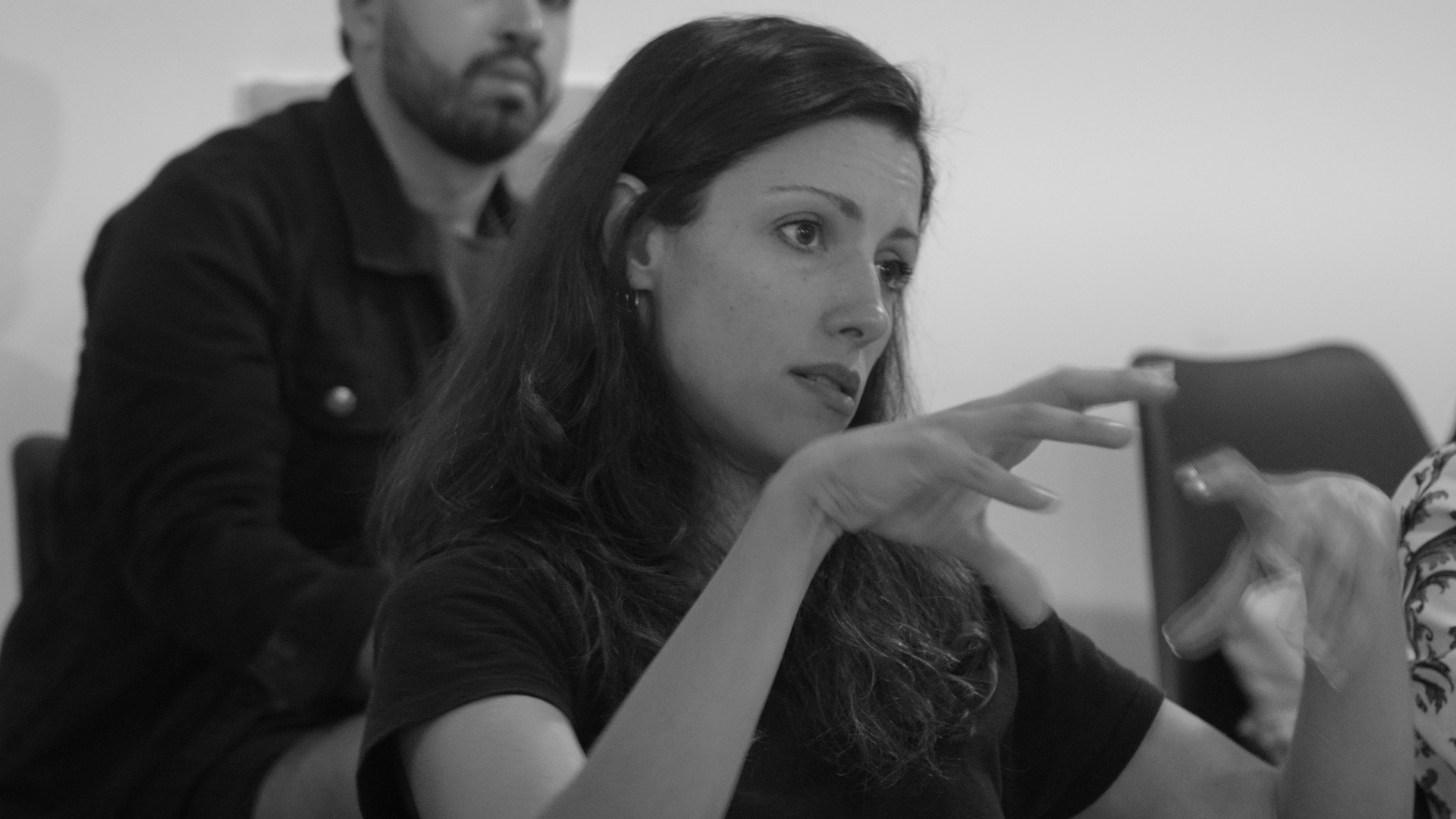 Black and white photo of a women performing modern dance on a dark background.