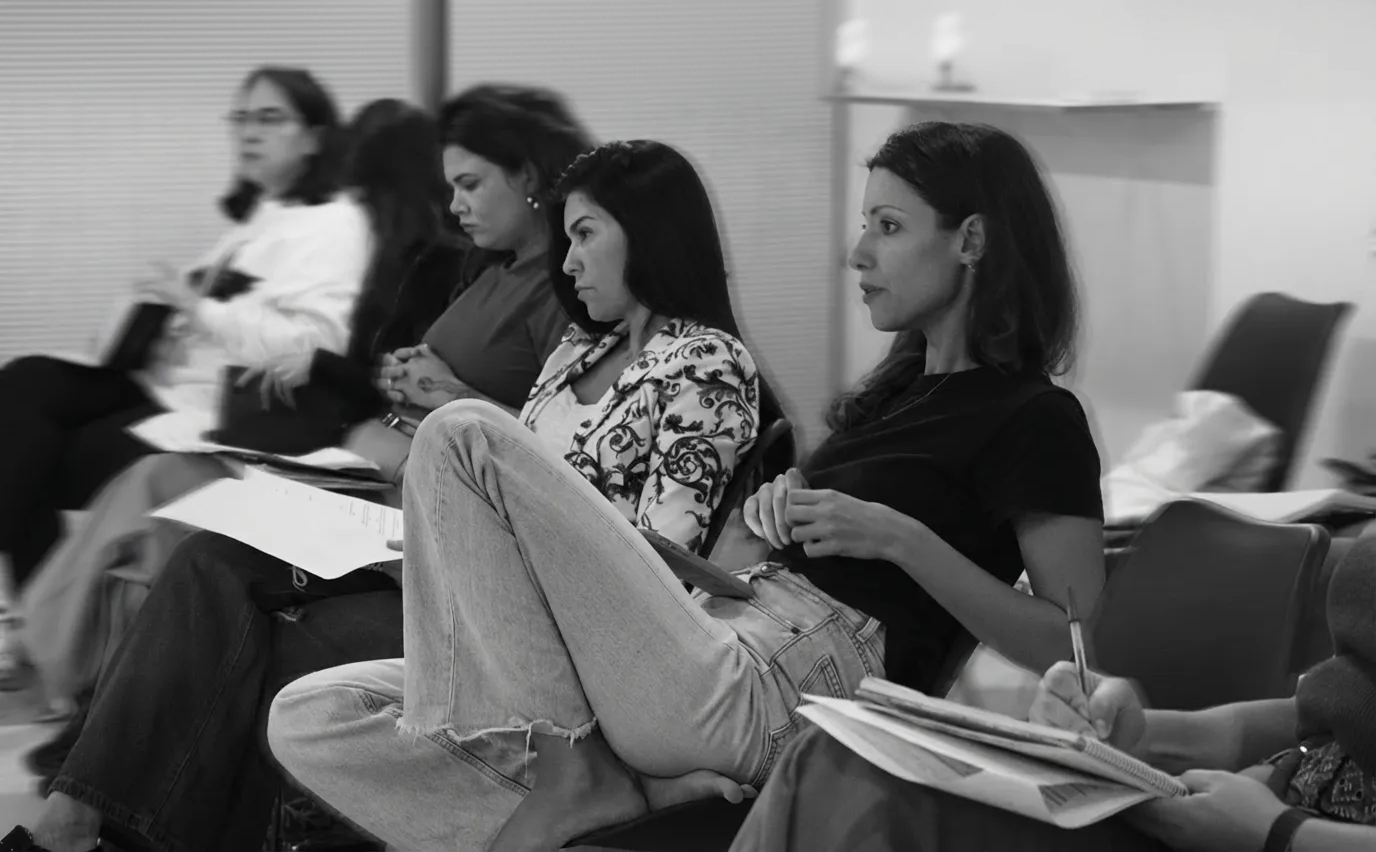 Black and white photo of teens rehearsing a dance routine on a stage.